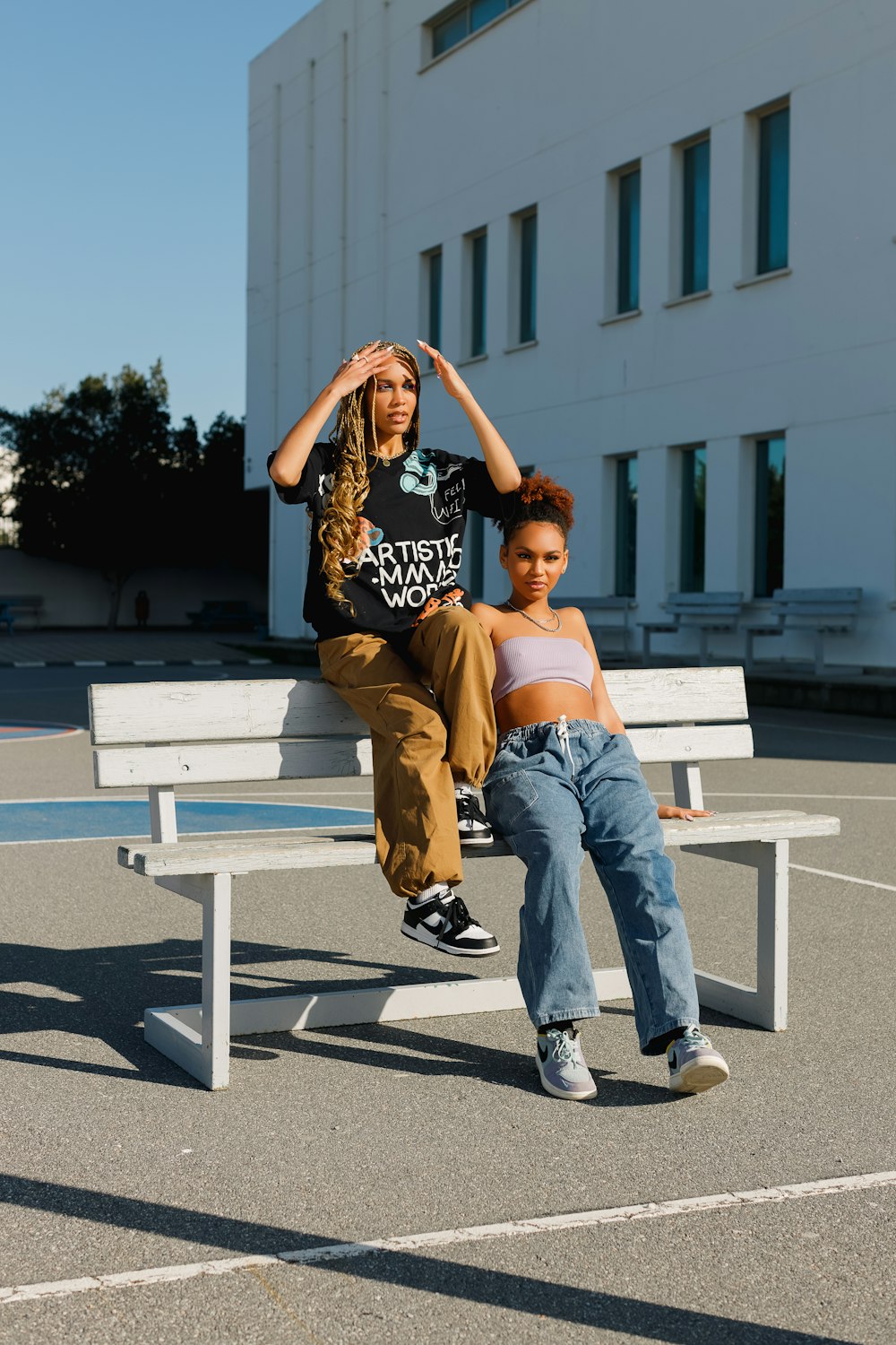 two people sitting on a bench in a parking lot