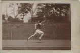 A professional shot of a man mid-sprint on an indoor track, embodying focus and high performance.