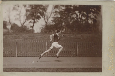 Black and white photo of a runner sprinting outdoors at dawn, muscles tense and focused.