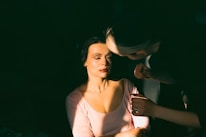 A close-up of a woman applying makeup in a bright, airy room.