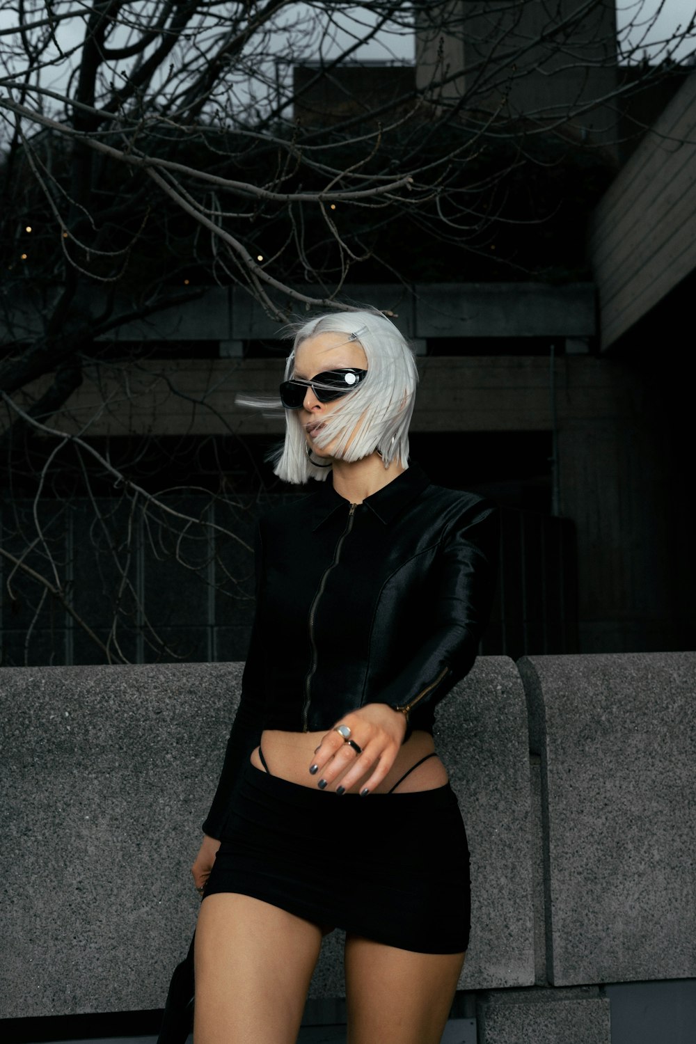 a woman with white hair wearing a black outfit