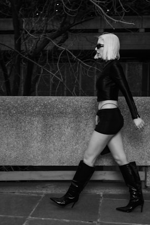 A model wearing essência wear's modern outfit walking confidently in an urban setting.