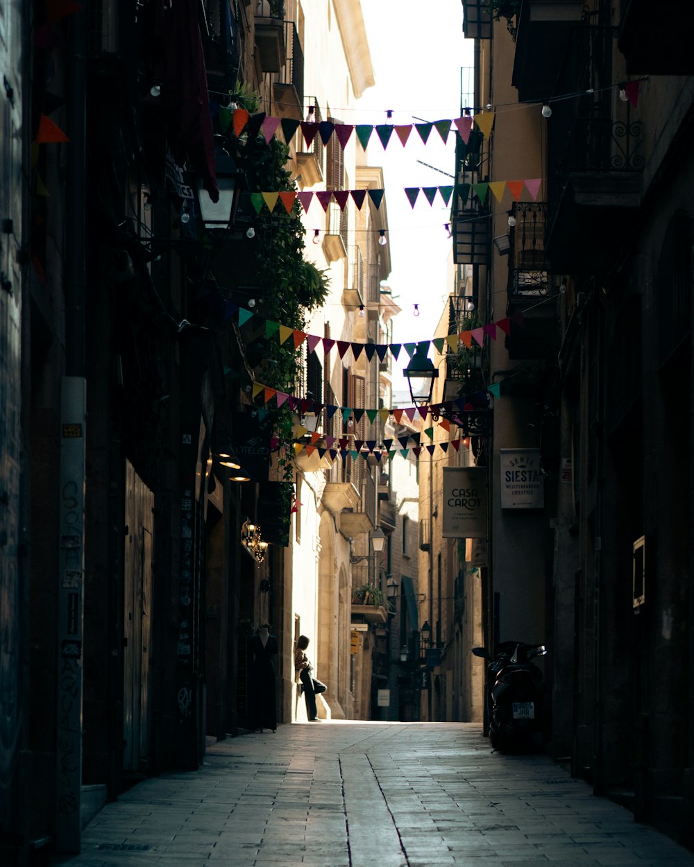 a narrow alleyway with a person walking down it