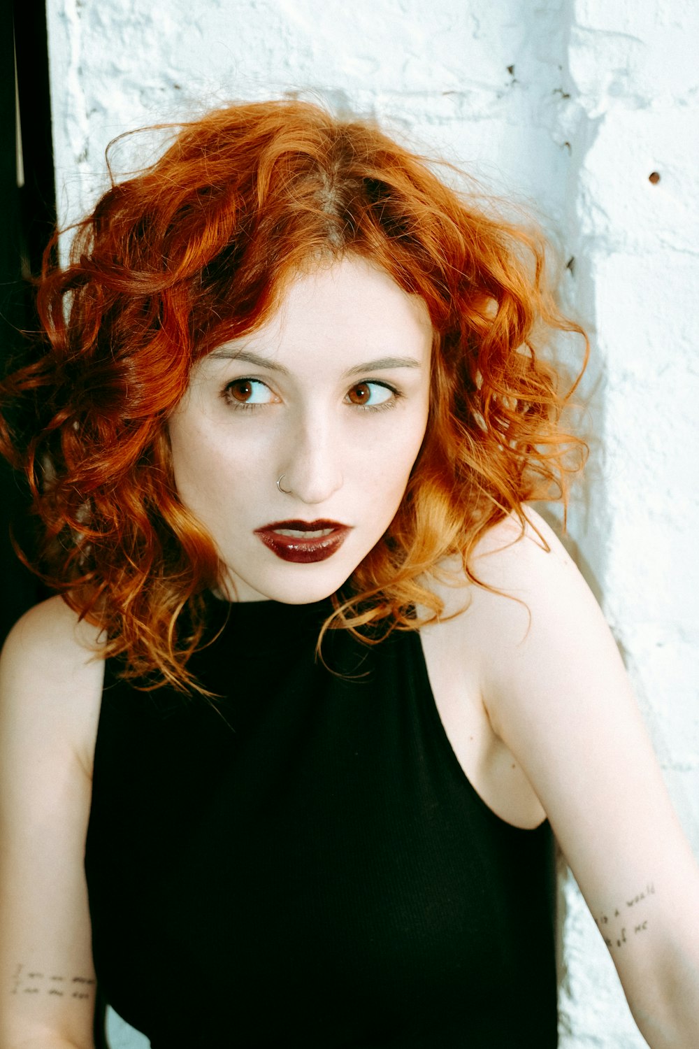 a woman with red hair wearing a black dress