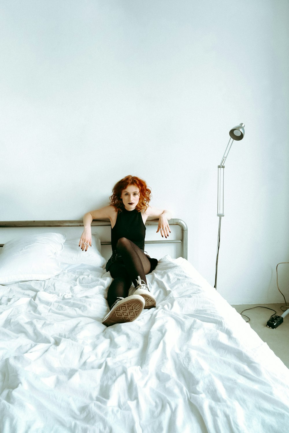 a woman sitting on top of a white bed