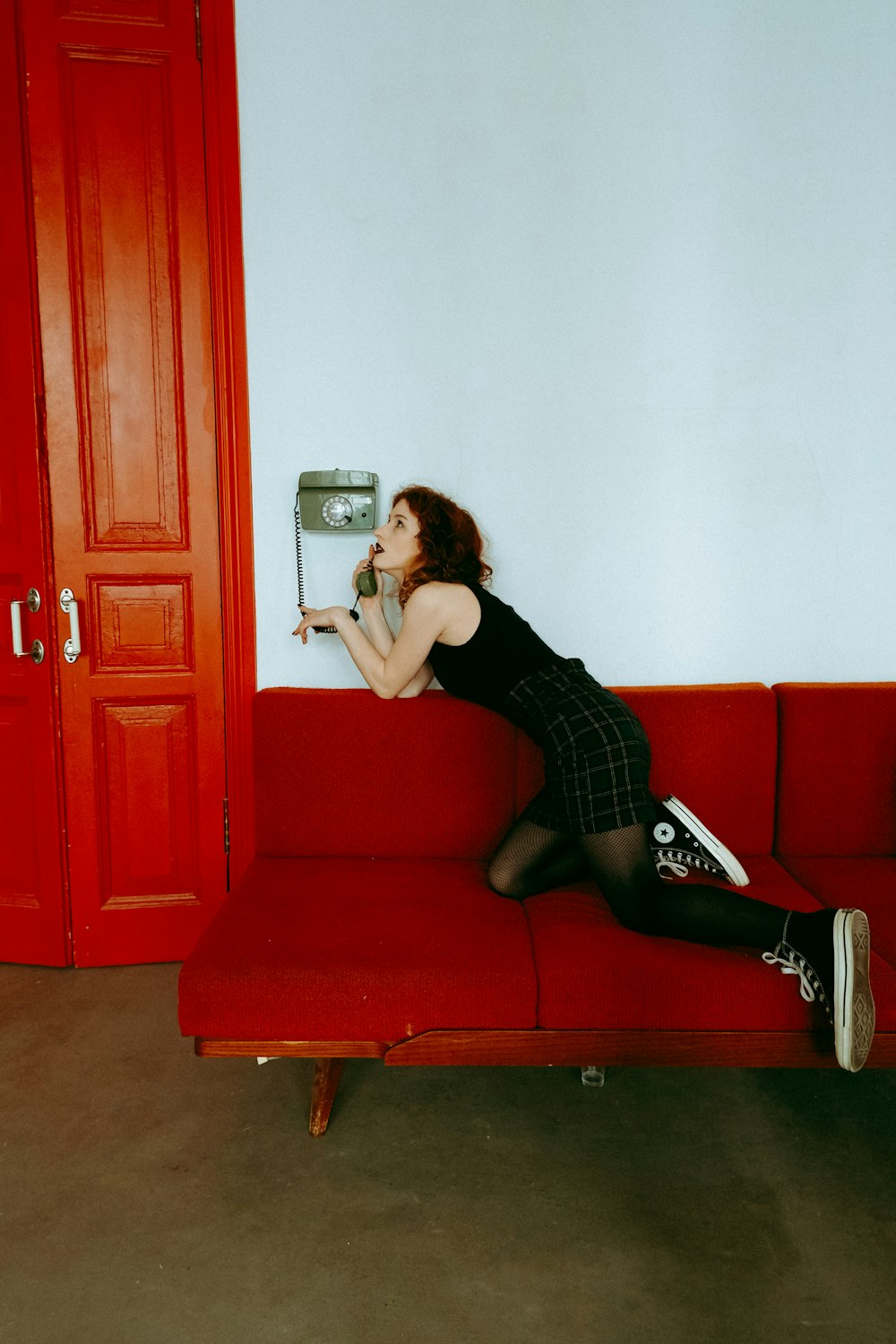 a woman sitting on a red couch in a room