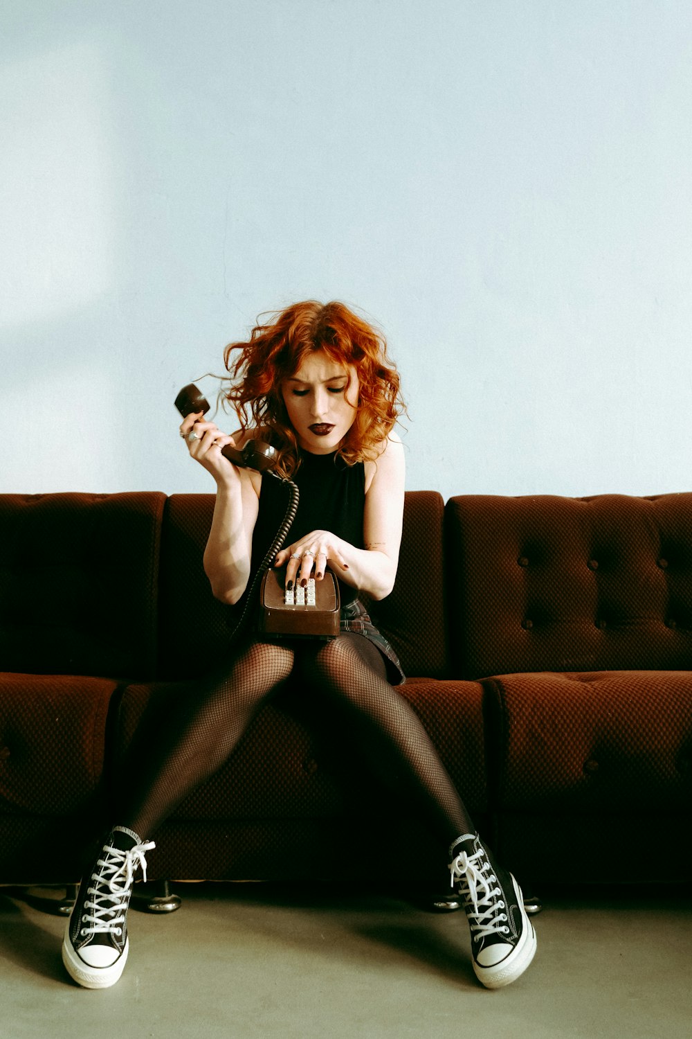 a woman with red hair sitting on a couch