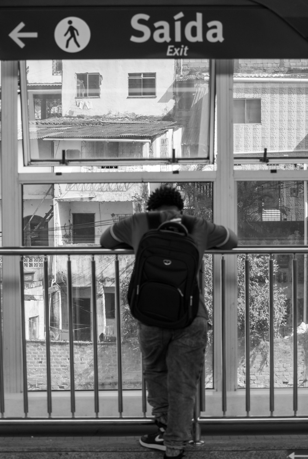 a man with a backpack looking out a window