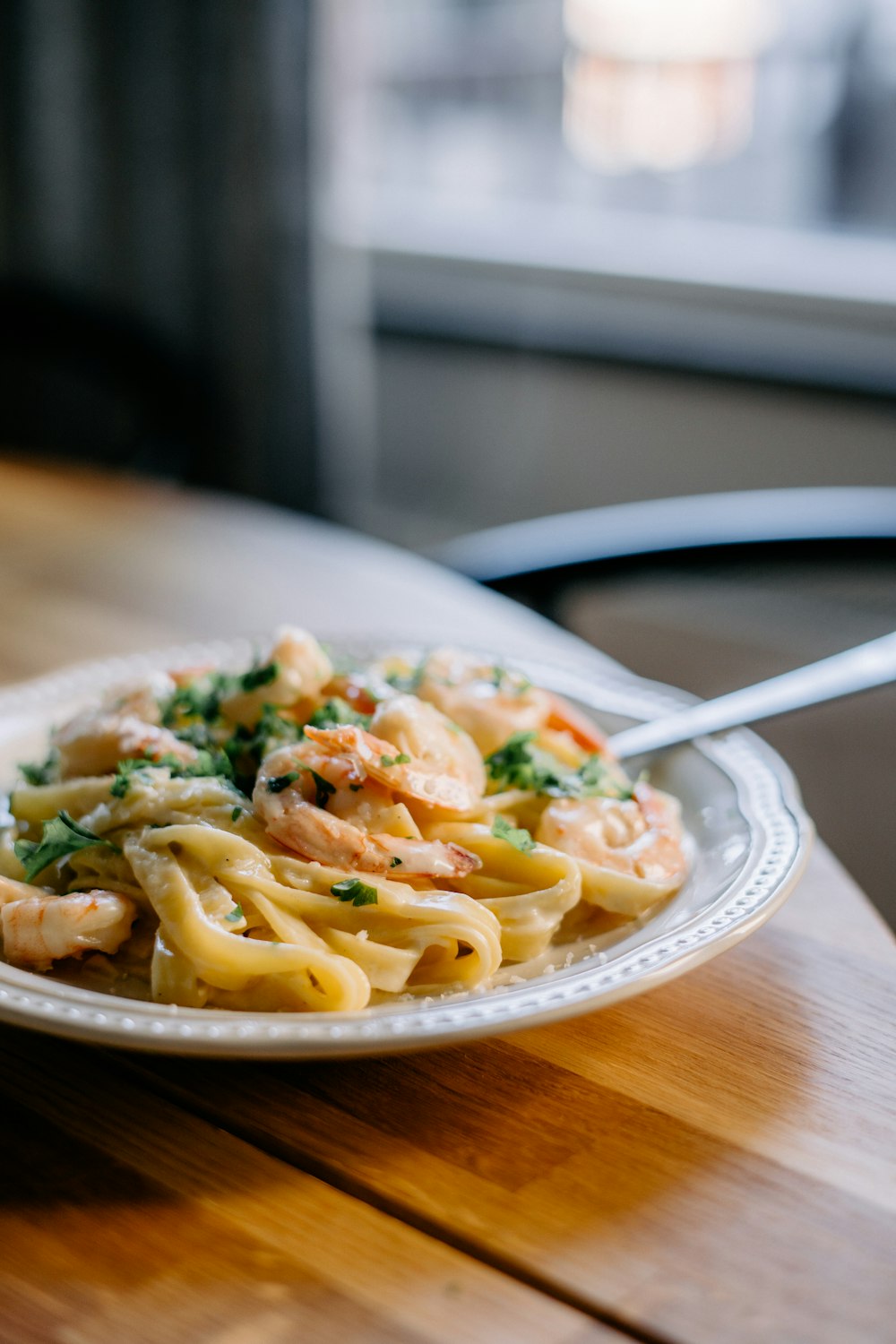 a plate of pasta with shrimp and broccoli