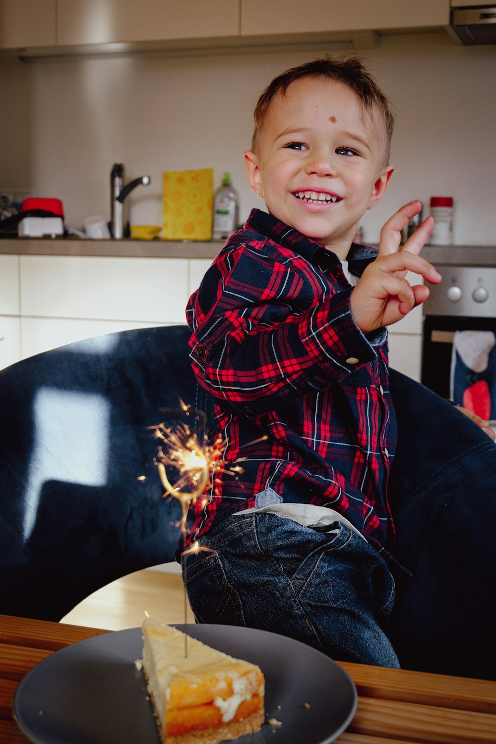 a young boy sitting in a chair with a piece of cake