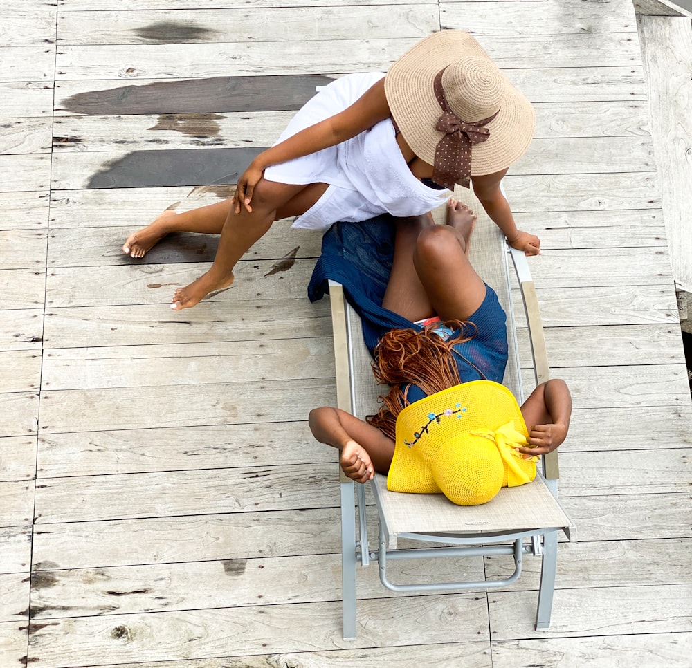 a couple of people sitting on top of a beach chair