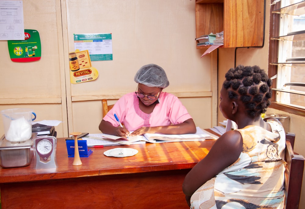 a woman sitting at a table with another woman