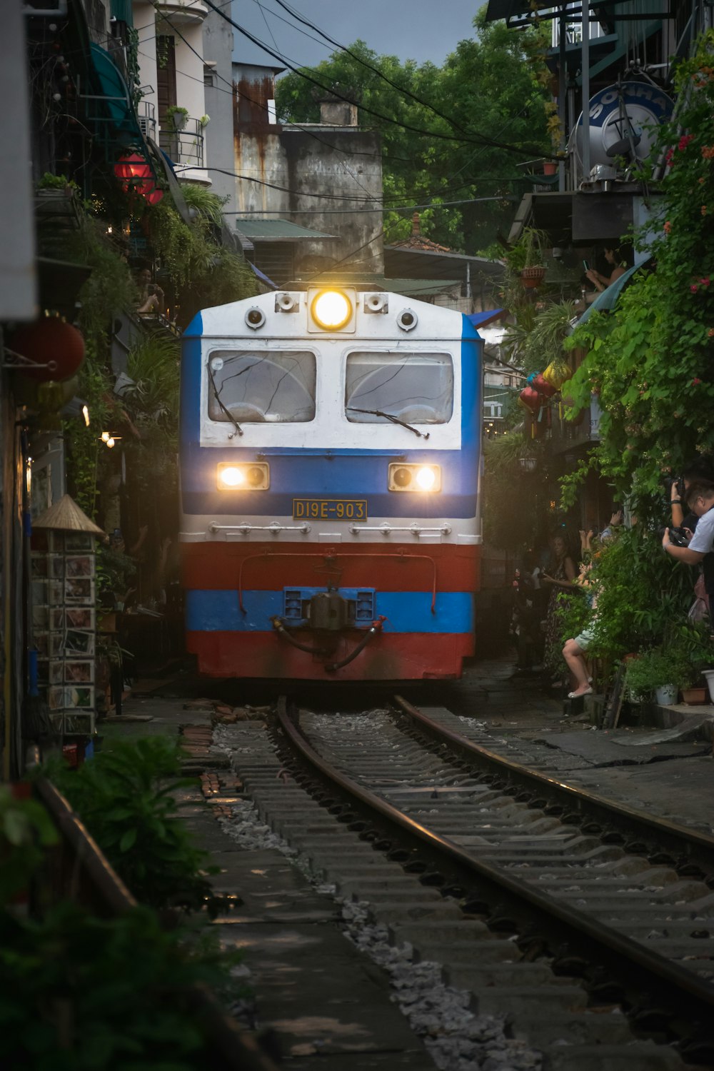 a blue and white train traveling down train tracks