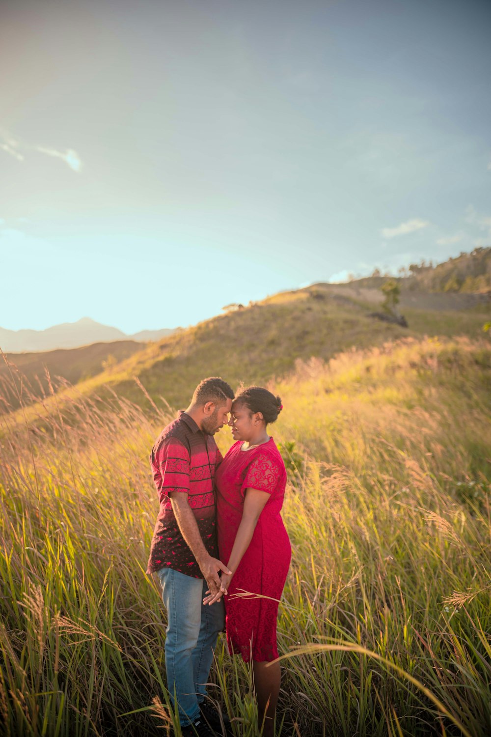 a man and woman standing in tall grass