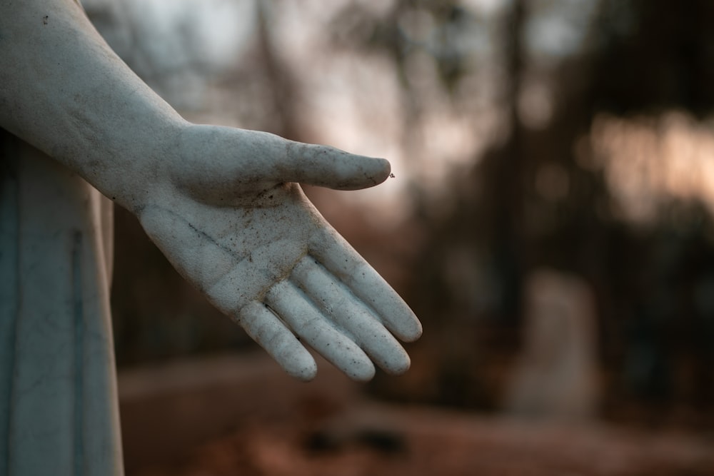una estatua de la mano de una persona sosteniendo algo