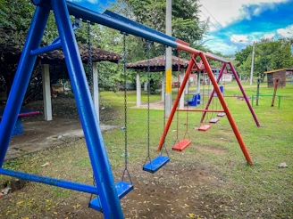 A bright orange and blue swing set with happy kids swinging energetically.