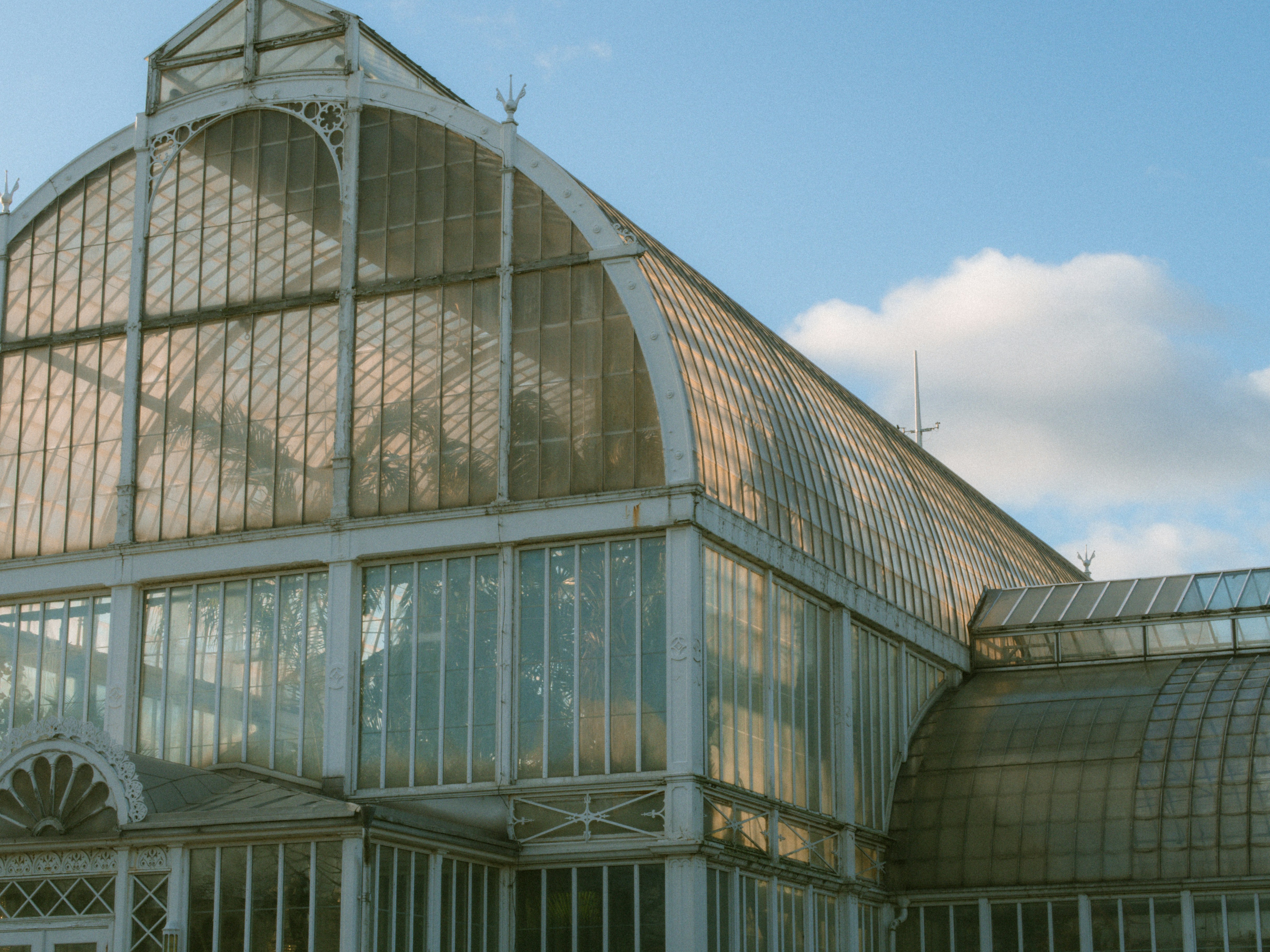 a large glass building with a clock on the side of it