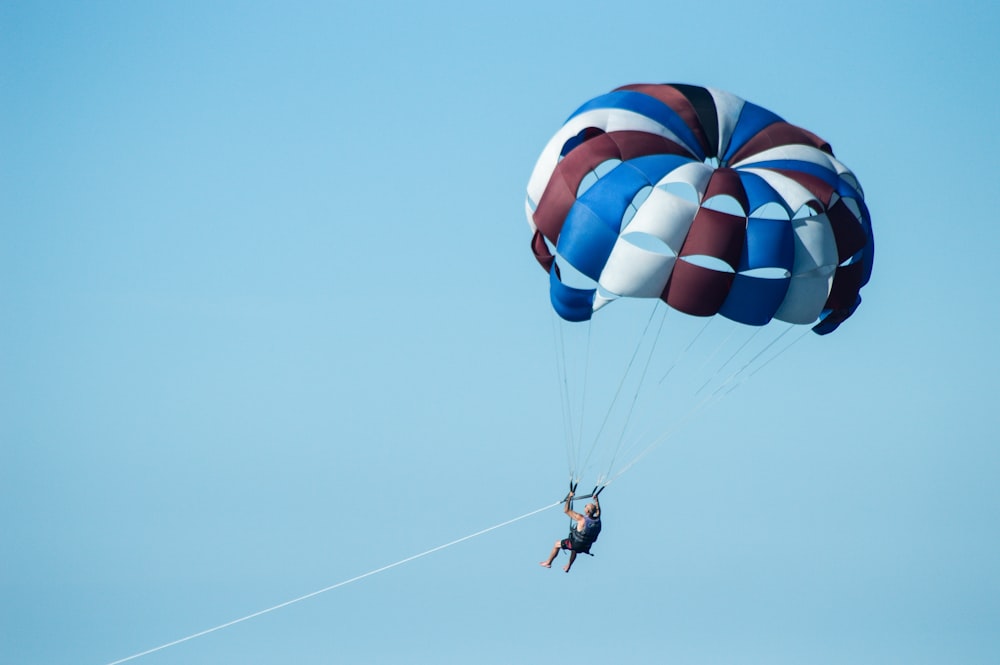 uma pessoa está parasailing no céu azul