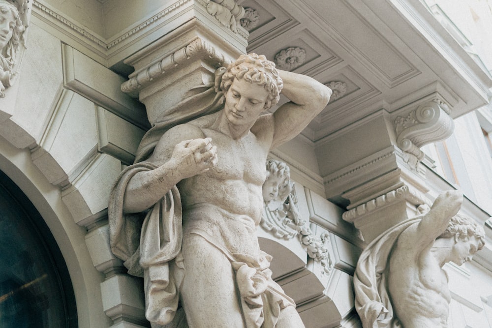 a statue of a man holding a bird on top of a building