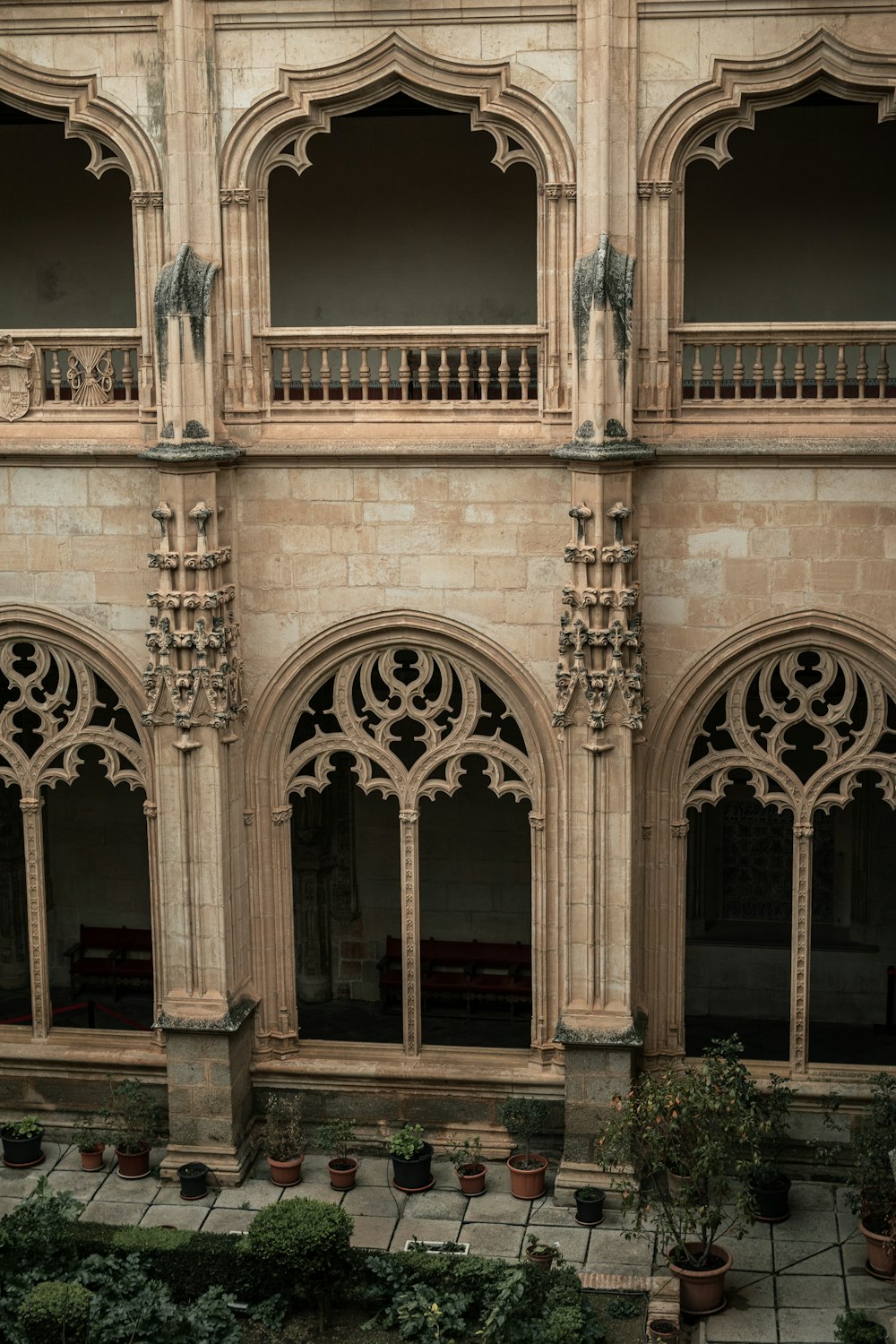 a large building with many windows and plants in the courtyard