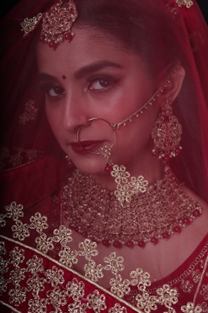 a woman in a red dress with a veil on her head