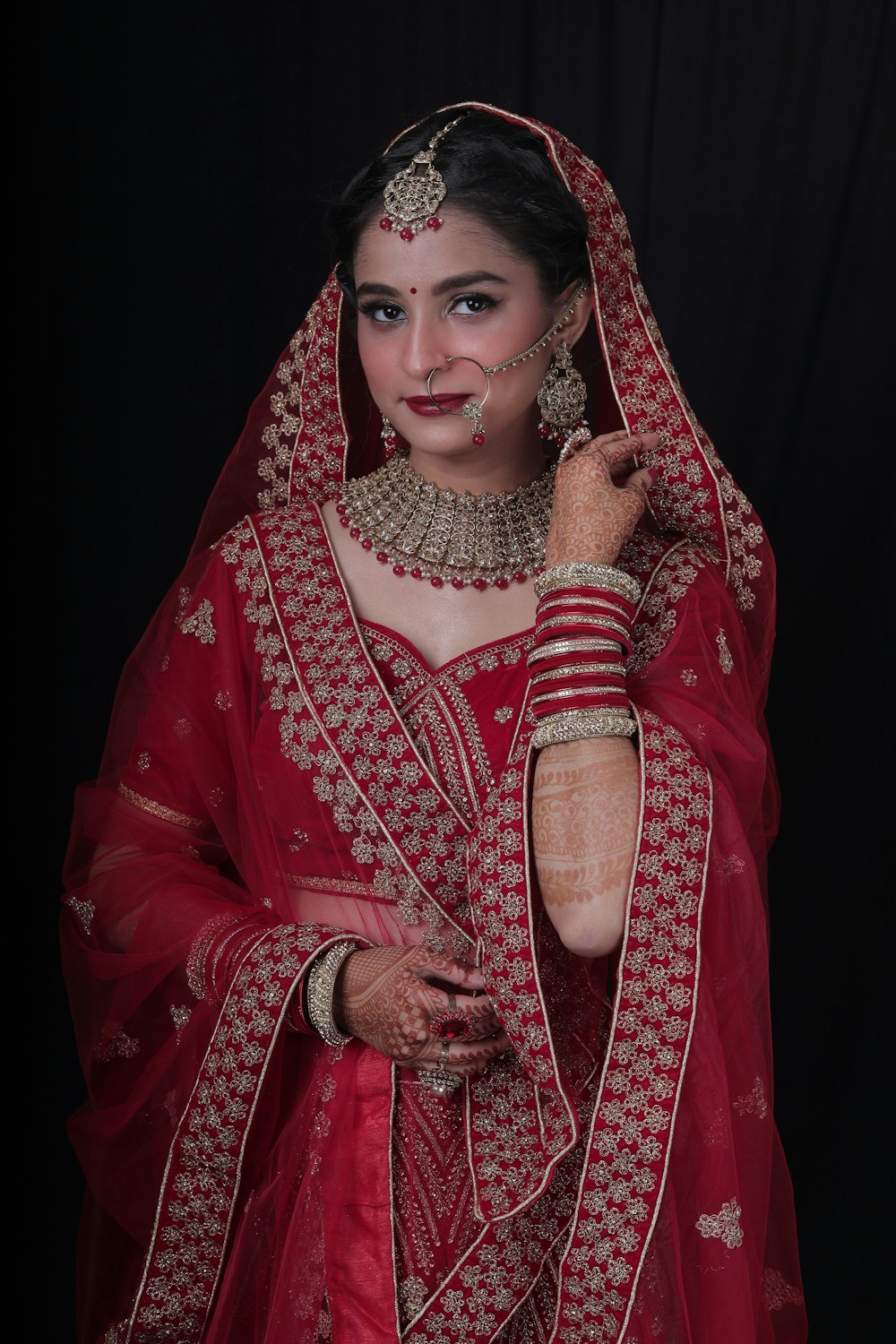 a woman in a red and gold bridal outfit