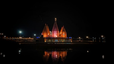 A peaceful evening view of the temple illuminated by lamps.