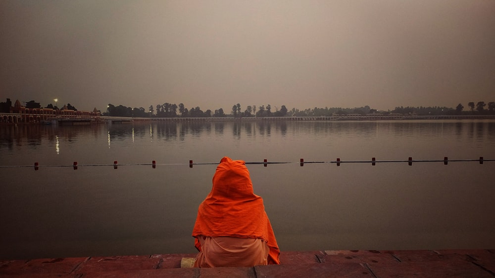 a person sitting on a dock looking at the water