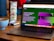 A laptop displaying a website about language models is set on a wooden table. A coffee cup is nearby, next to a menu stand featuring a beef dish advertisement.