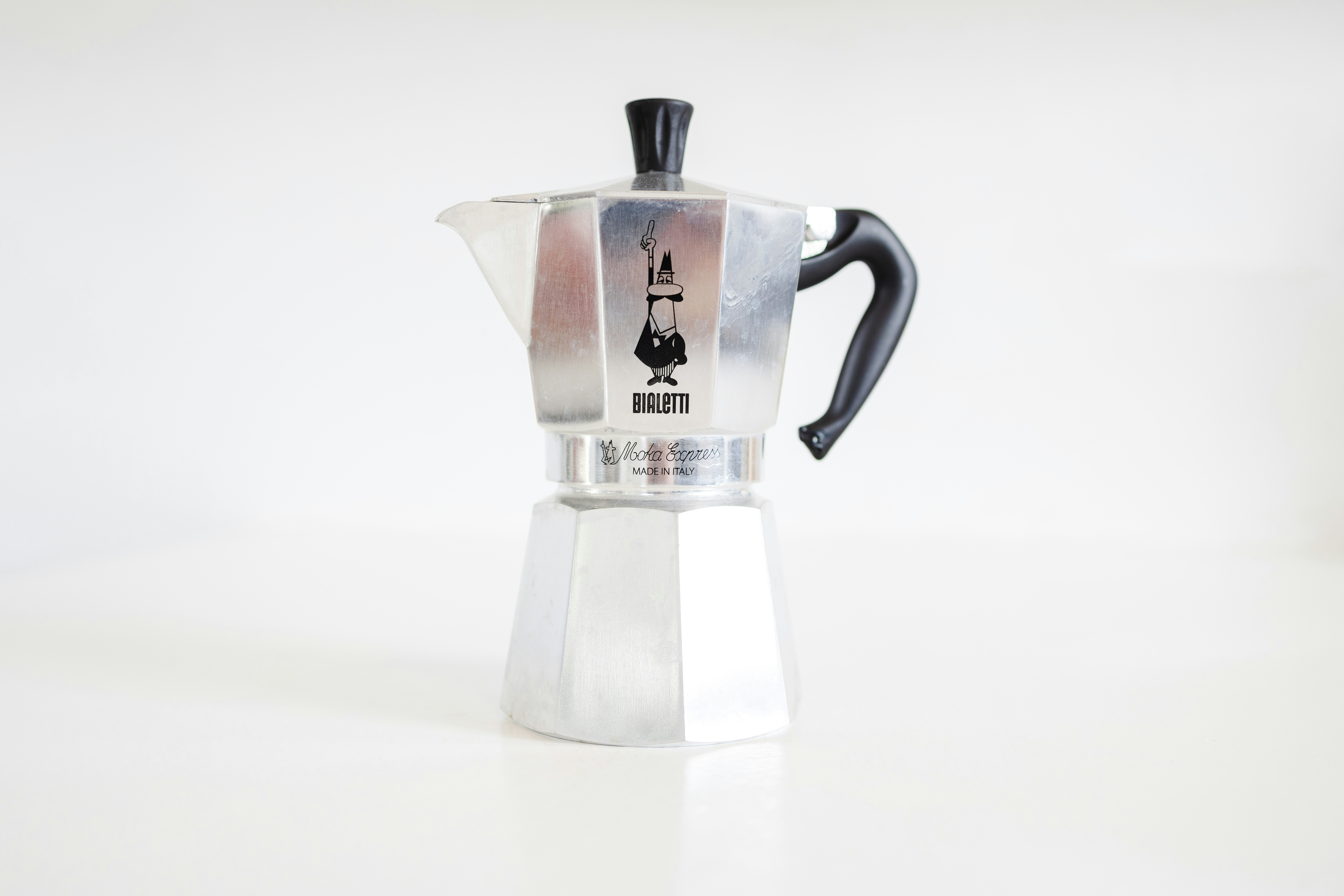 a stove top coffee maker on a white table