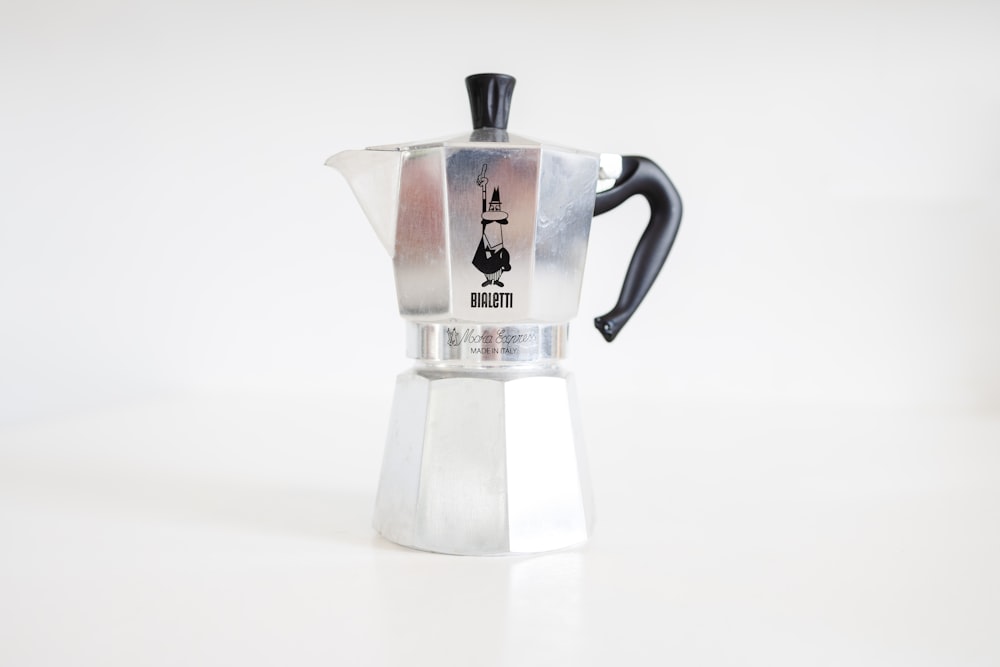 a stove top coffee maker on a white table