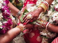 A close-up of hands tied together during the saptapadi ritual, symbolizing unity and tradition.