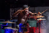 Ezra Hurricane energetically drumming in a dimly lit rehearsal room.