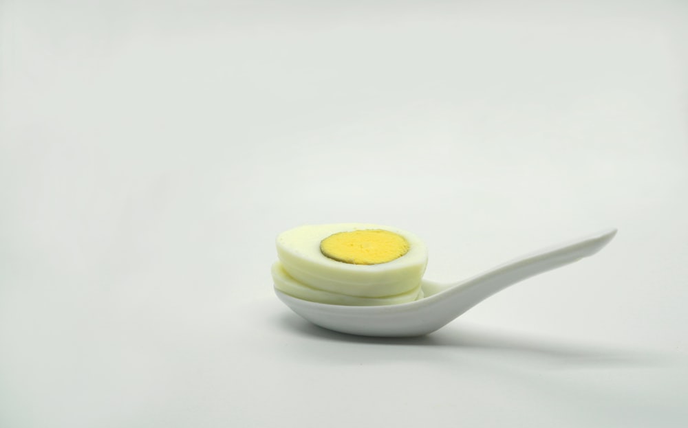 a white spoon with a yellow substance on it