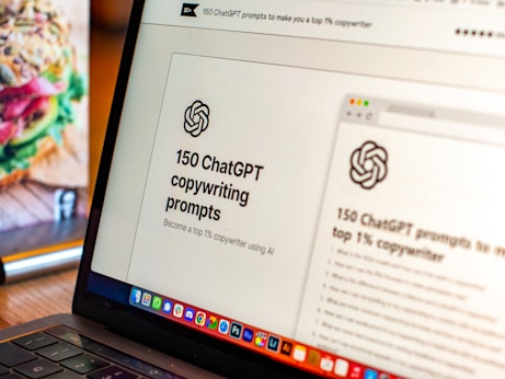 A laptop displays a webpage titled '150 ChatGPT copywriting prompts' with a logo above the text. It suggests using AI to improve copywriting skills. On the left, part of a colorful sandwich is partially visible, adding a contrast to the academic theme on the screen.