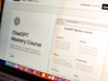 A laptop screen displays a webpage with the title 'ChatGPT Mastery Course'. The page includes sections on Learning, Writing, Money, Marketing, Productivity, and Tools, with various bullet points under each category. The top right shows an open browser tab, and there is a rating section with stars in the top left. Bright icons of various applications are visible at the bottom of the screen.