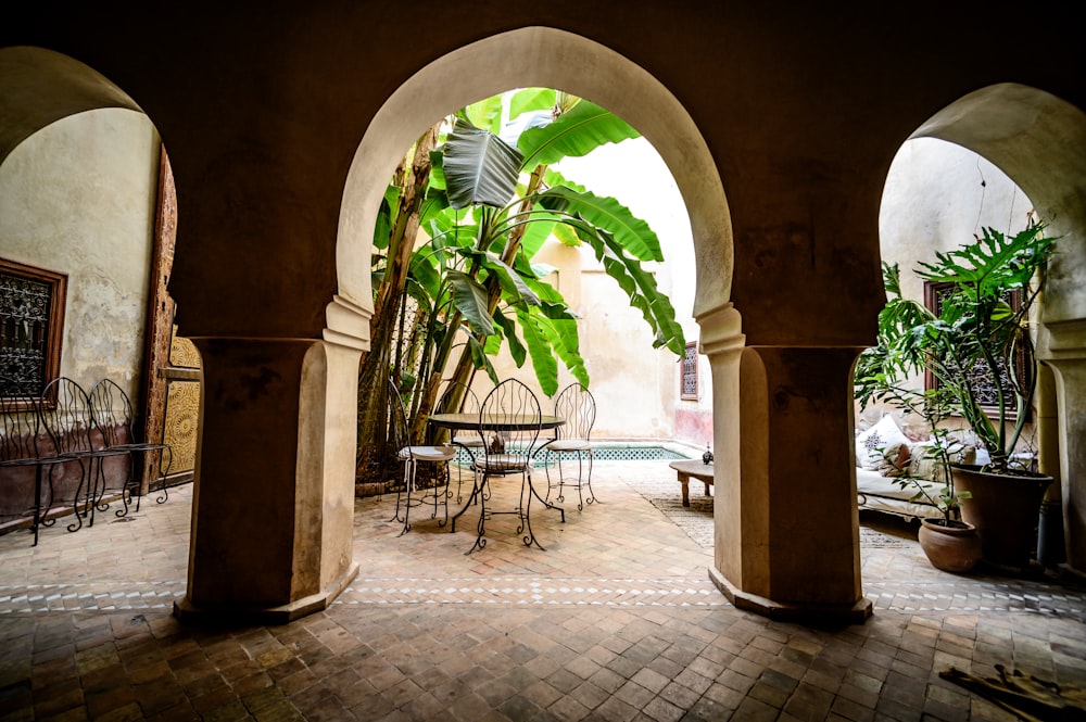 a courtyard with a table and chairs and a potted plant