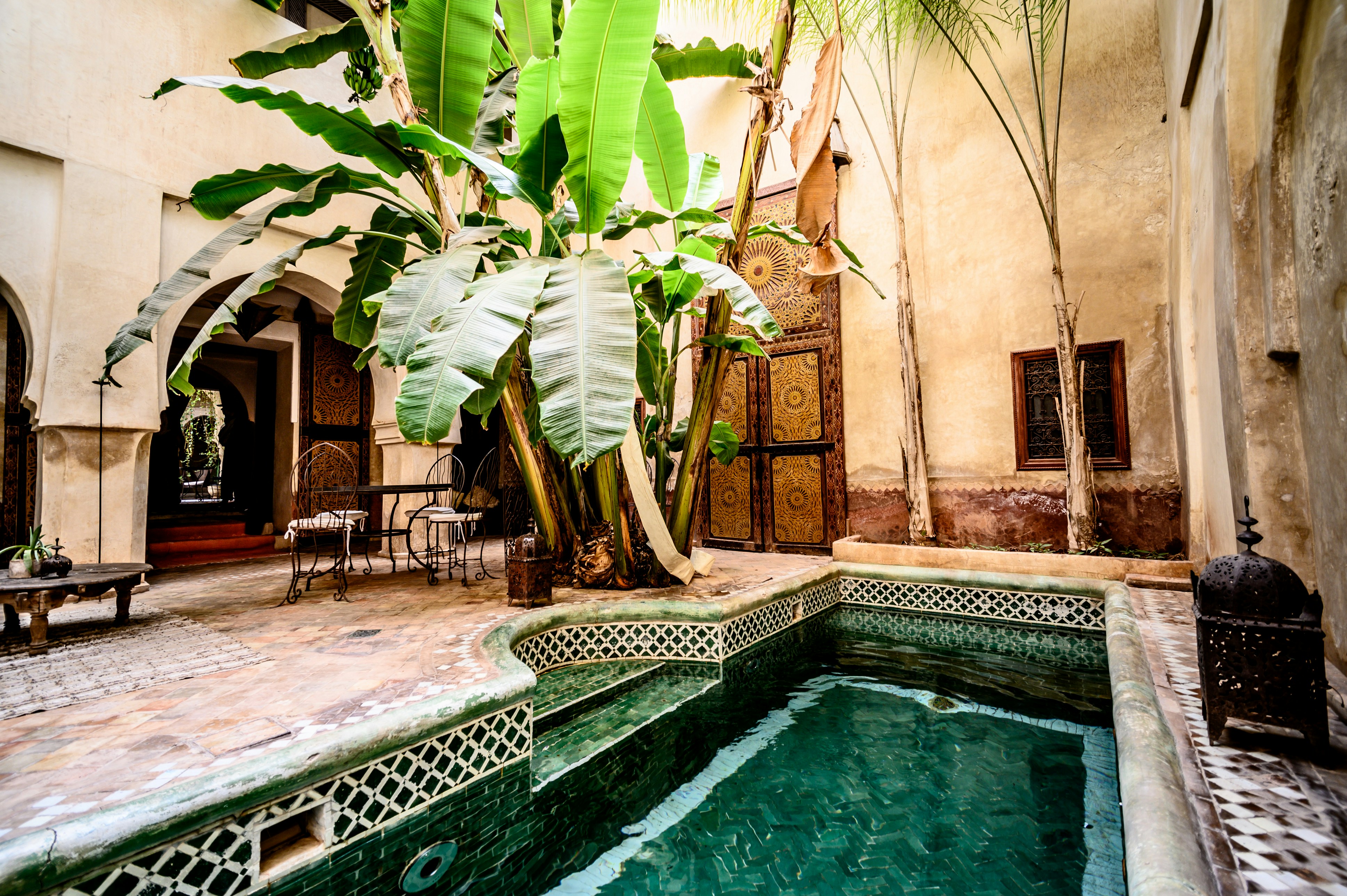 Casa Arvona dining courtyard with candlelit tables, tropical plants, and warm evening atmosphere