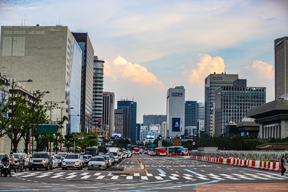 a city street filled with lots of traffic next to tall buildings