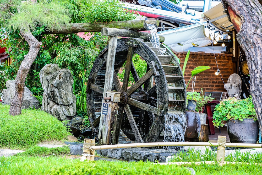 a water wheel in the middle of a garden