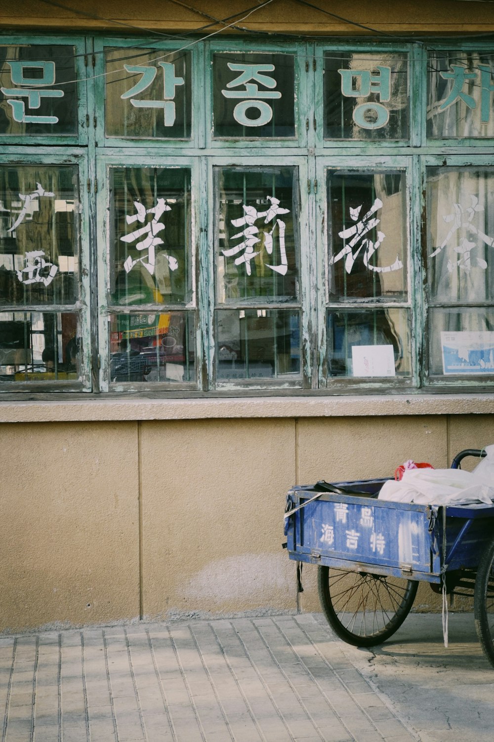 a bike parked in front of a building with asian writing on the windows