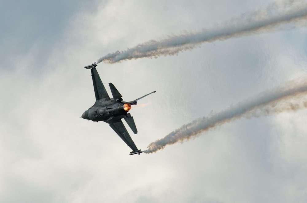 um jato de combate voando através de um céu nublado