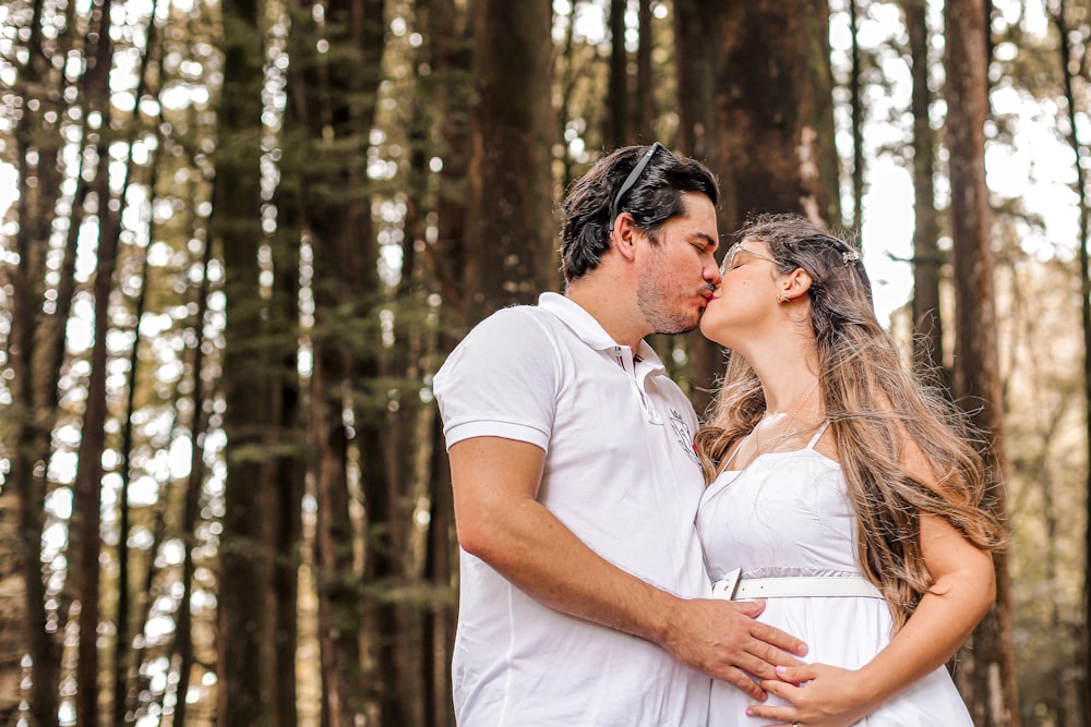 a man and a woman kissing in the woods