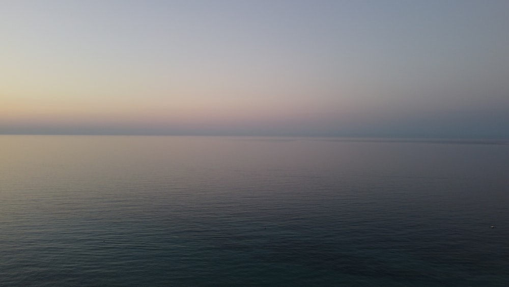 a large body of water with a sky in the background