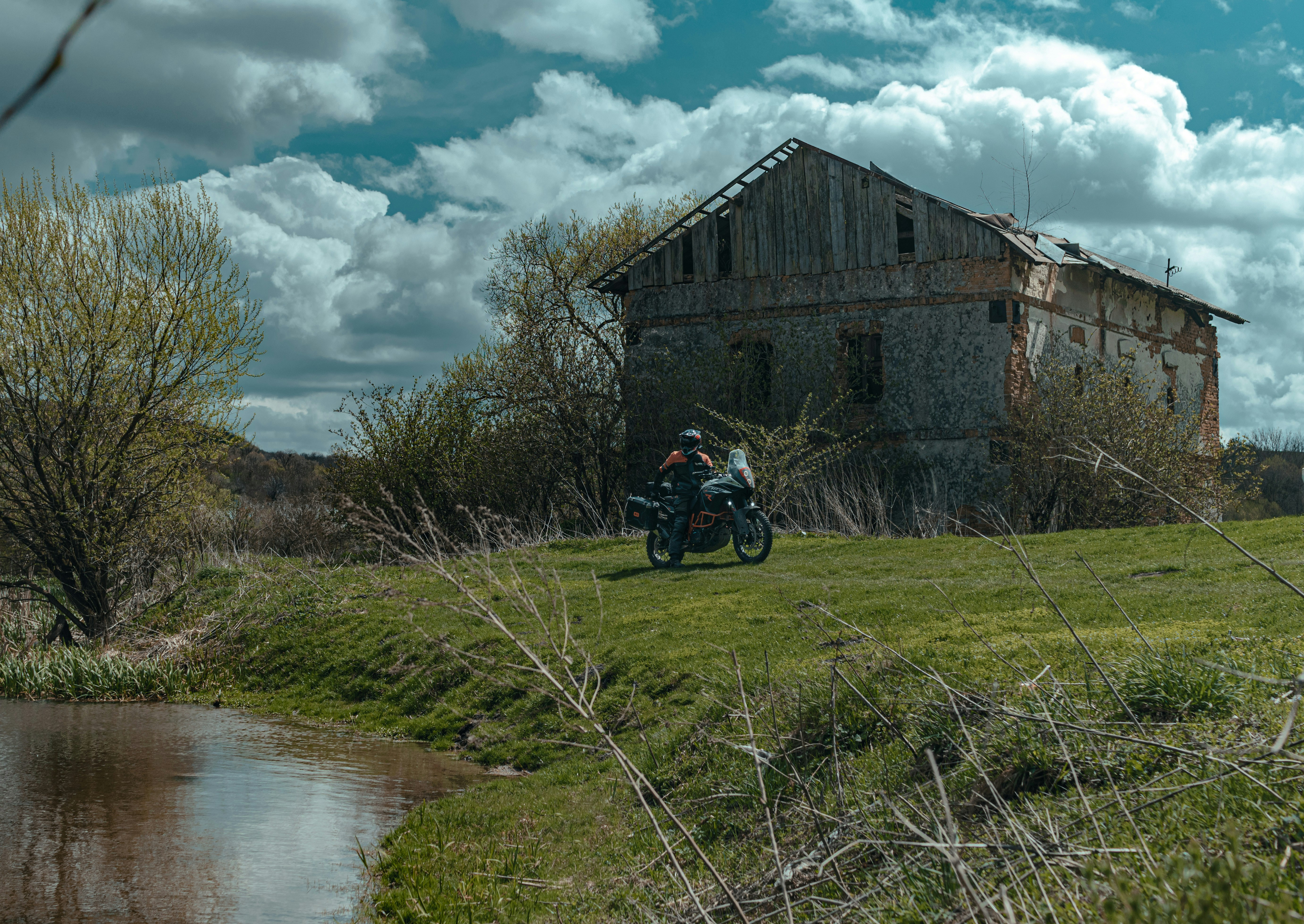 Ein Mann fährt mit dem Motorrad einen üppigen grünen Hügel hinunter