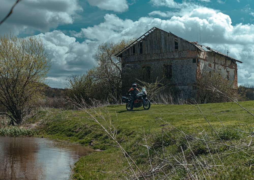 a man riding a motorcycle down a lush green hillside