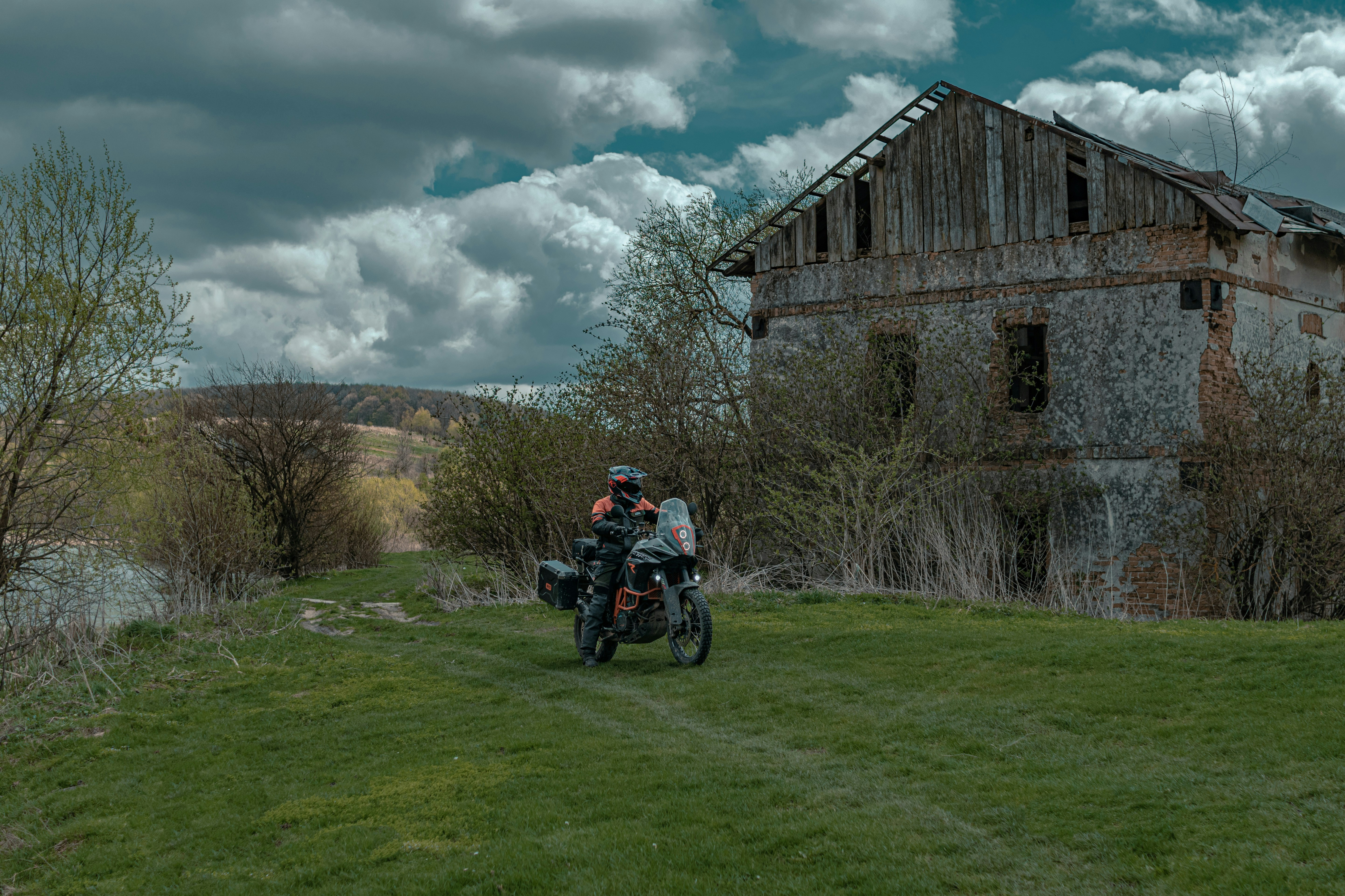 a man riding a motorcycle on a lush green field