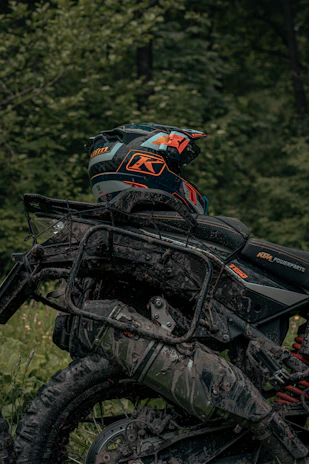 Close-up of a worn helmet resting on a dirt bike, dust and scratches telling stories of past adventures.