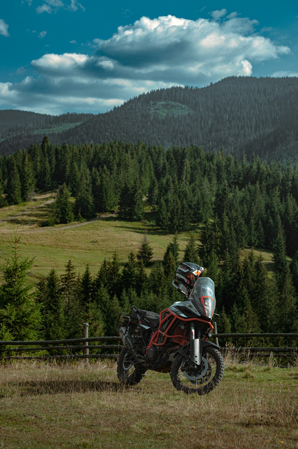 a motorcycle parked in a field with a mountain in the background