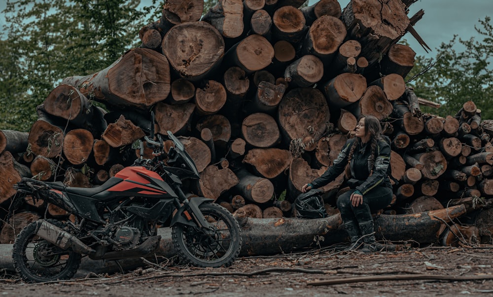 a motorcycle parked next to a pile of logs